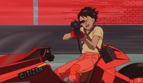 Tetsuo filming something on Kaneda's bike in Akira