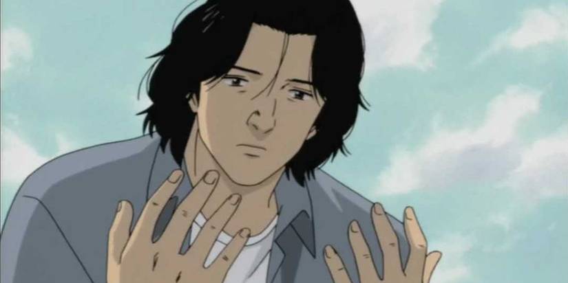 Dr. Kenzou Tenma looks at his hands in Monster.