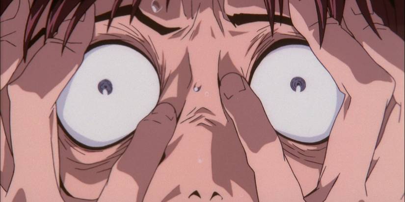 Shinji grips his face in stress as he loses his mind in The End of Evangelion.
