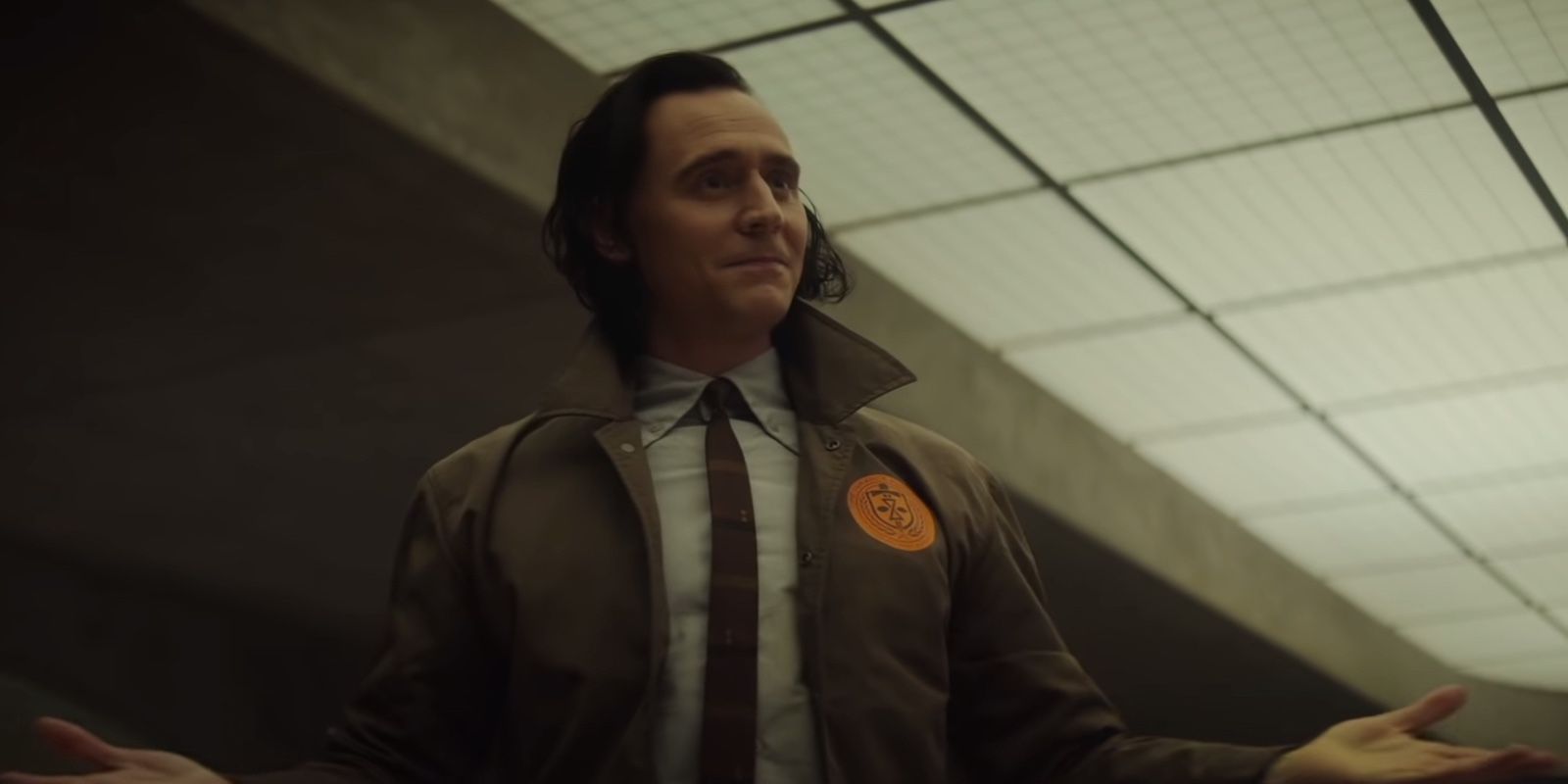Loki em um traje da TVA sorrindo em Loki do Disney Plus