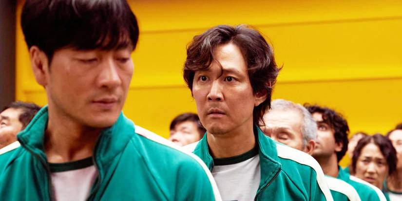 Sang-woo and Gi-hun standing in a line on Squid Game