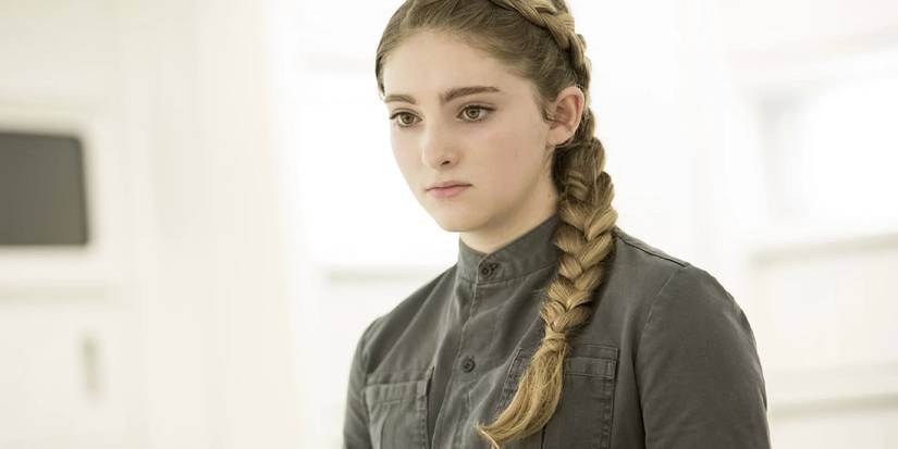 Primrose (Willow Shields) stands in a white room in The Hunger Games.