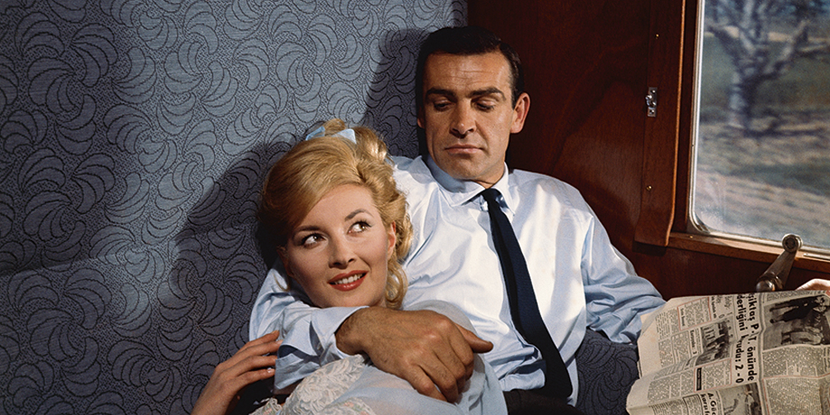 From Russia with Love, Sean Connery as James Bond with his arm around a woman
