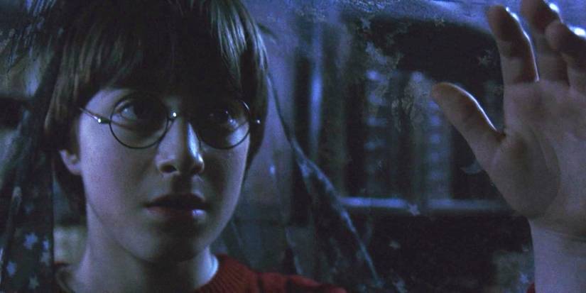 Harry Potter holding the Invisibility Cloak in Harry Potter and the Sorcerer's Stone