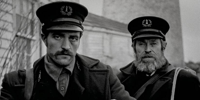 Dafoe and Pattinson look at a solemn expression in the lighthouse.