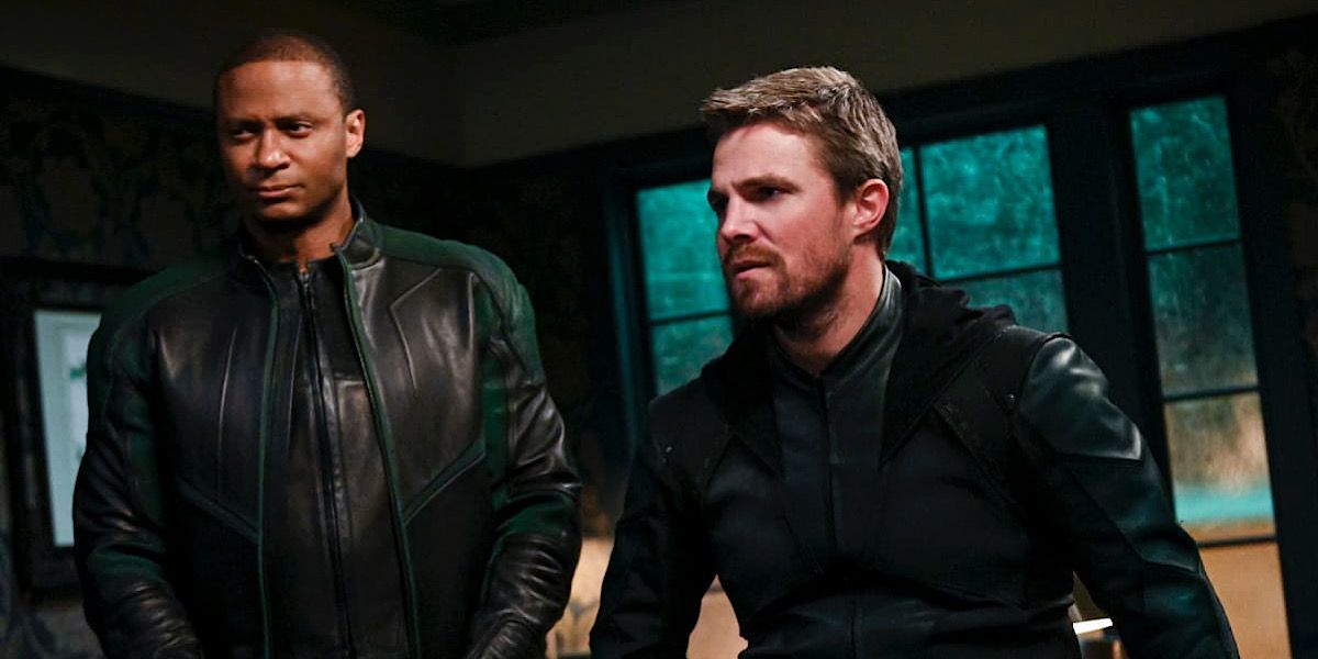 John Diggle standing beside Oliver Queenwho is sitting down - Arrow