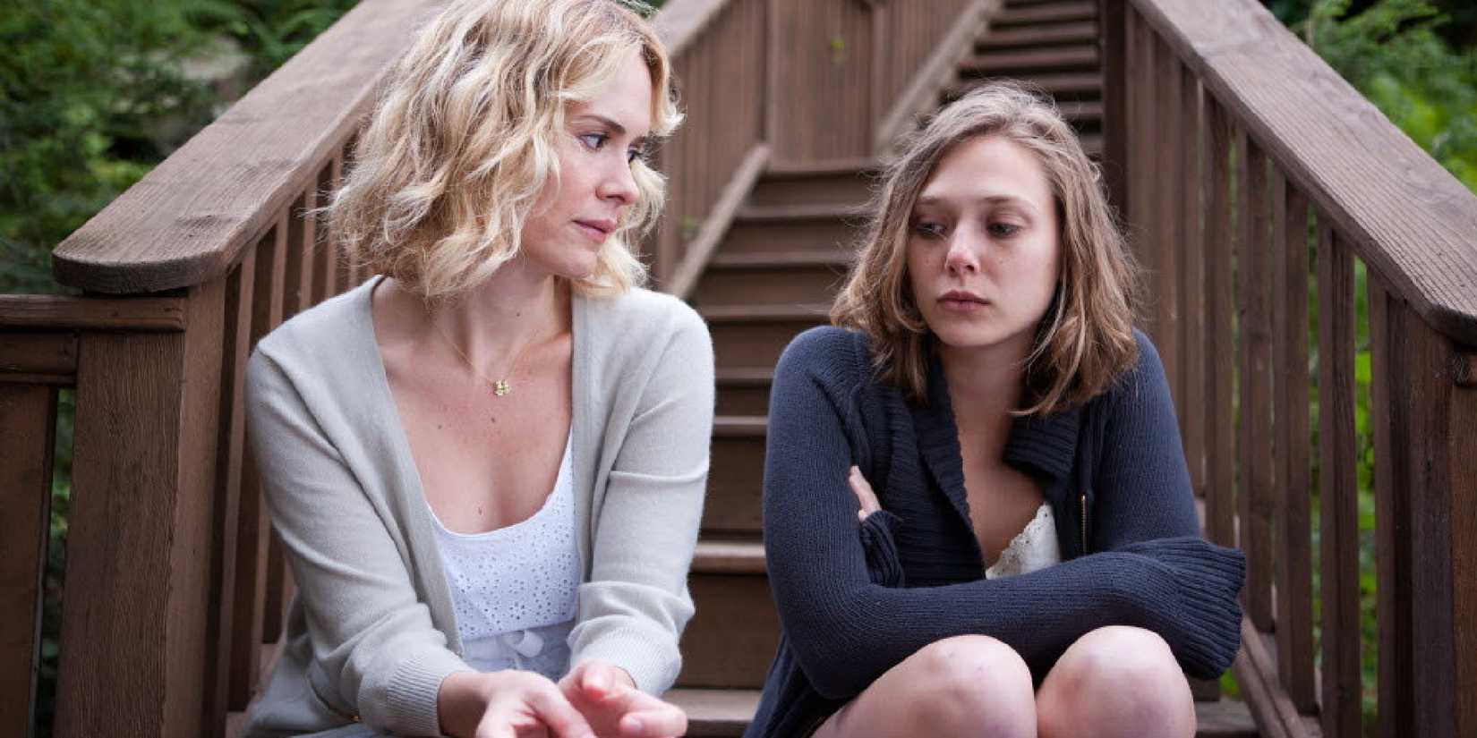 Sarah Paulson and Elizabeth Olsen sit on the stairs in Martha Marcy May Marlene