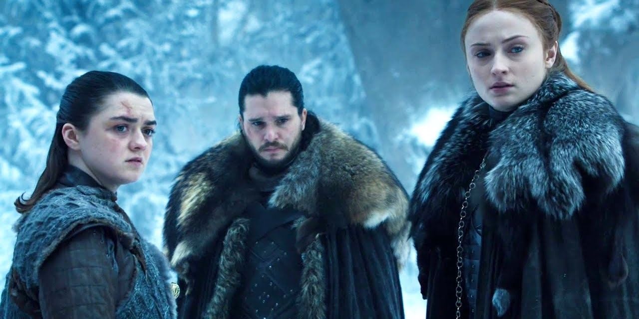 Arya Stark, Jon Snow e Sansa Stark olhando para alguém em Winterfell