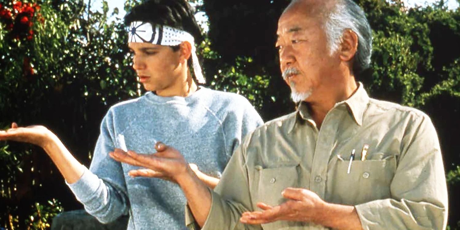 Mr. Miyagi stands next to Daniel and teaches him martial arts - The Karate Kid
