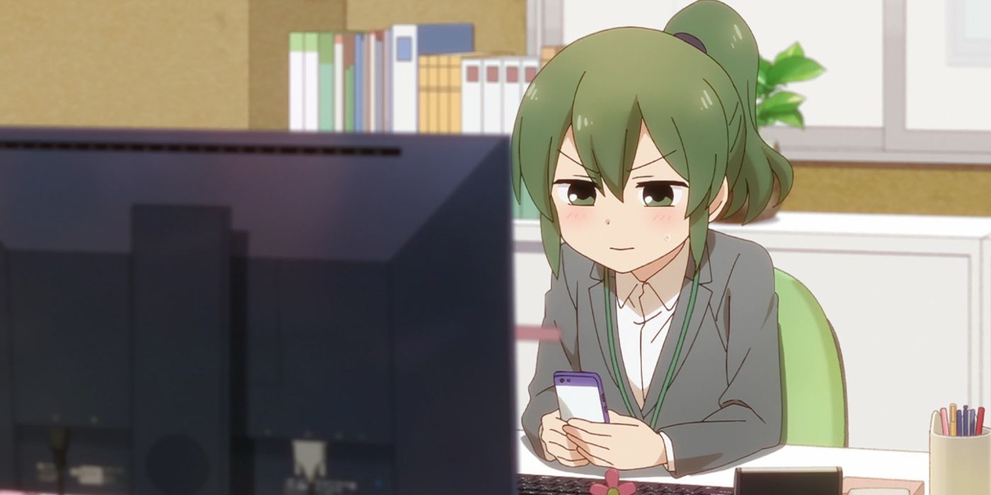 Futaba from My Senpai Is Annoying sitting at her computer using her phone