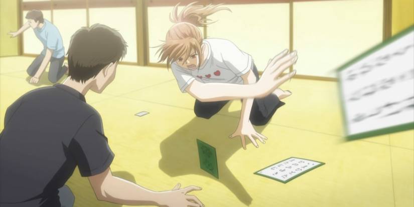 Chihaya swiping a card away while playing karuta in Chihayafuru.