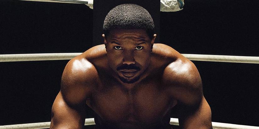 Michael B Jordan sits in his corner in a boxing ring during Creed 3