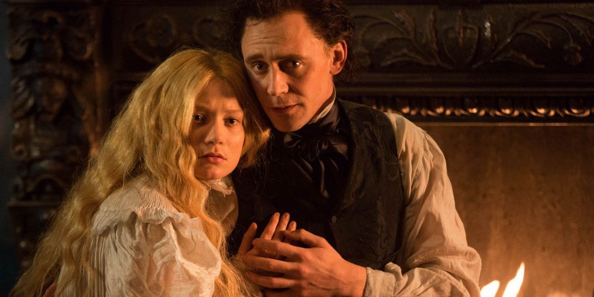Edith and Thomas Sharpe hold each other by the fire in the film, Crimson Peak.