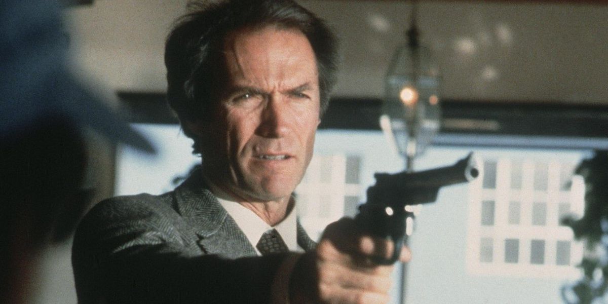 Clint Eastwood como Harry Callahan segurando uma arma inclinada para o lado direito da tela.