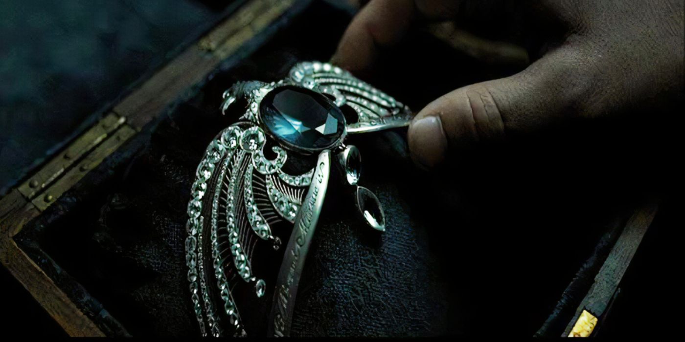 Uma mão segurando o diadema da Corvinal em Harry Potter e as Relíquias da Morte