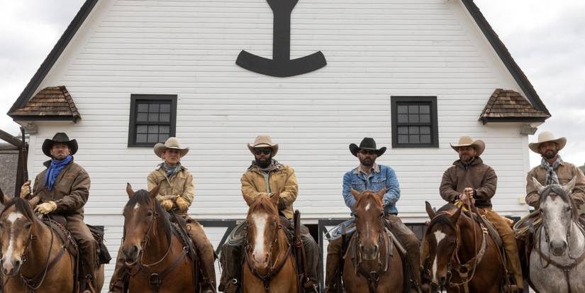 The cowboys sit on their horses in front of the ranch on Yellowstone.