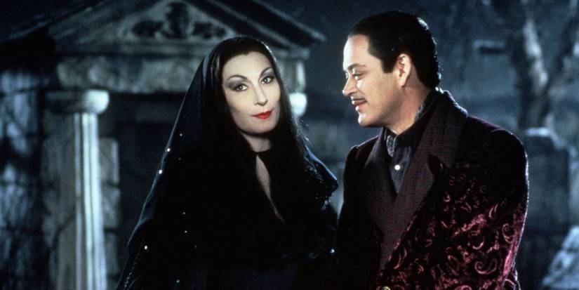 Gomez and Morticia outside the family mausoleum in the Addams family.