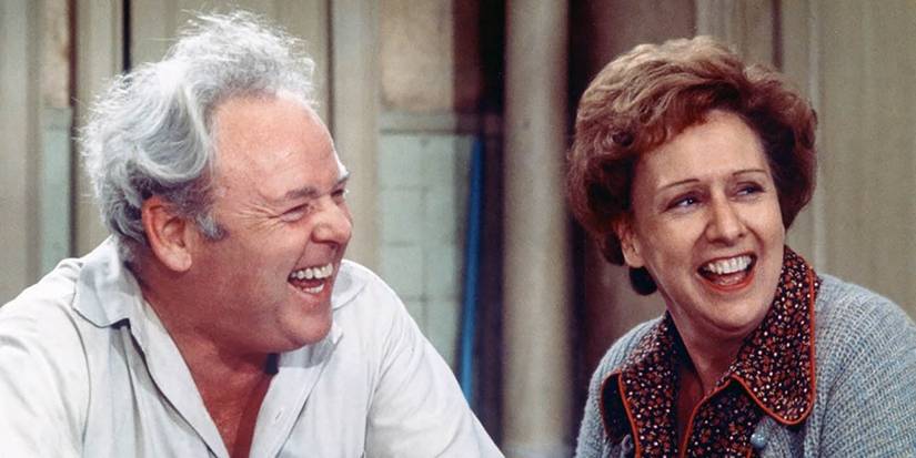 Archie and Edith Bunker laughing in a scene of all in the family.