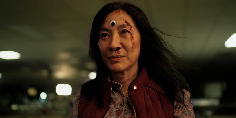 Evelyn (Michelle Yeoh) is smiling while blood drips down her face in Everything Everywhere All at Once.