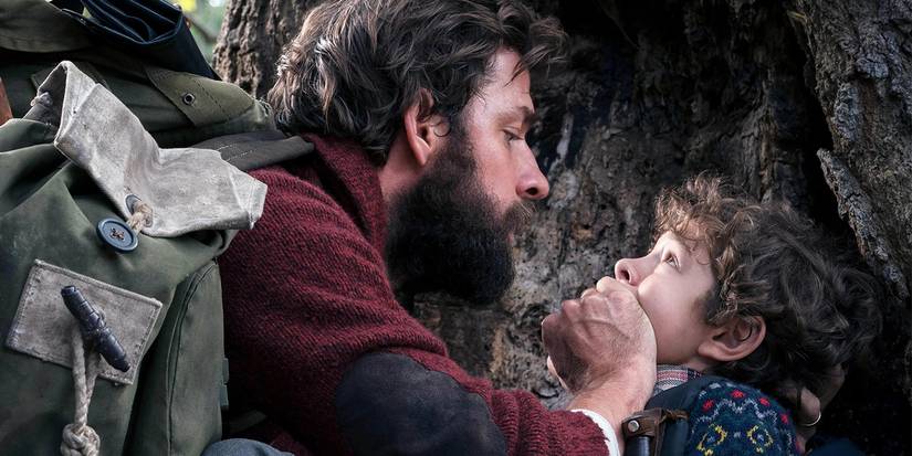 Lee (John Krasinski) covers his son's mouth in A Quiet Place.