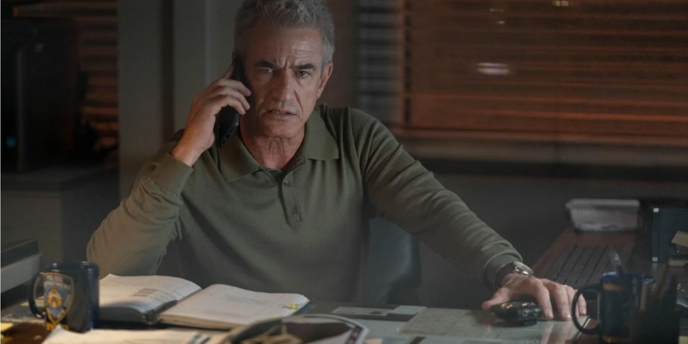 Detective Bailey sitting at his desk on the phone in Scream 6.
