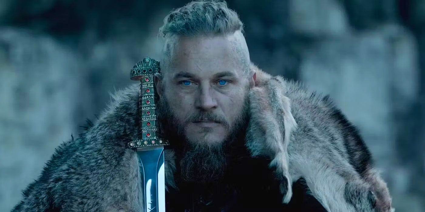 Ragnar Lothbar dressed in skins, holds a sword against his shoulder in Vikings.