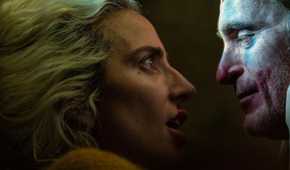 Lady Gaga holding Joaquin Phoenix's face in a scene from Joker 2.