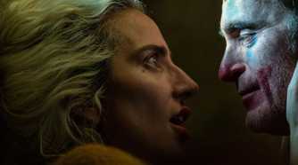 Lady Gaga holding Joaquin Phoenix's face in a scene from Joker 2.