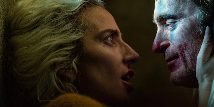 Lady Gaga holding Joaquin Phoenix's face in a scene from Joker 2.