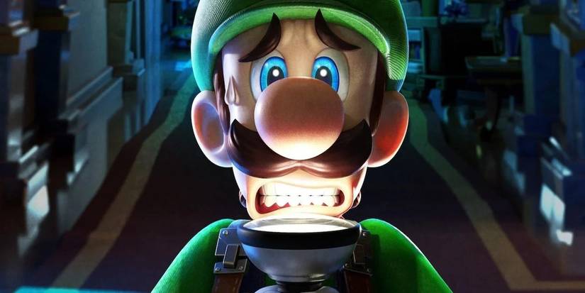 Luigi shines a light on his face in Luigi's Mansion.