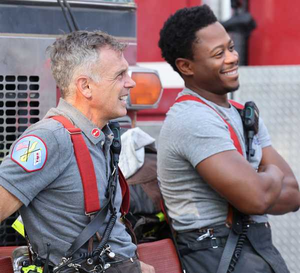 Chicago Fire's Ritter and Herrmann (Daniel Kyri and David Eigenberg) next to fire truck