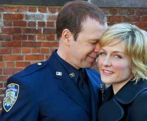 Blue Bloods' Danny Reagan leans against Linda Reagan while she looks into the camera.