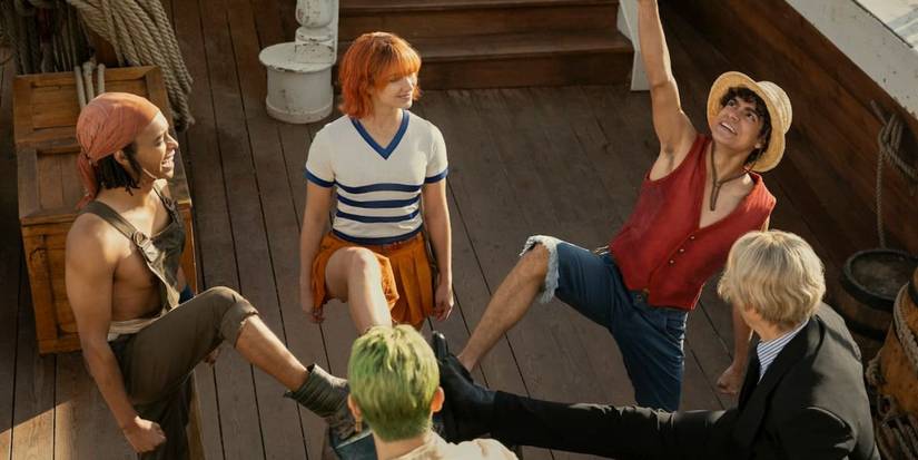 Monkey D. Luffy (Iñaki Godoy), Sanji (Taz Skylar), Roronoa Zoro (Mackenyu), Usopp (Jacob Romero Gibson), and Nami (Emily Rudd) each have their foot on a barrel in celebration in the live-action One Piece adaptation.