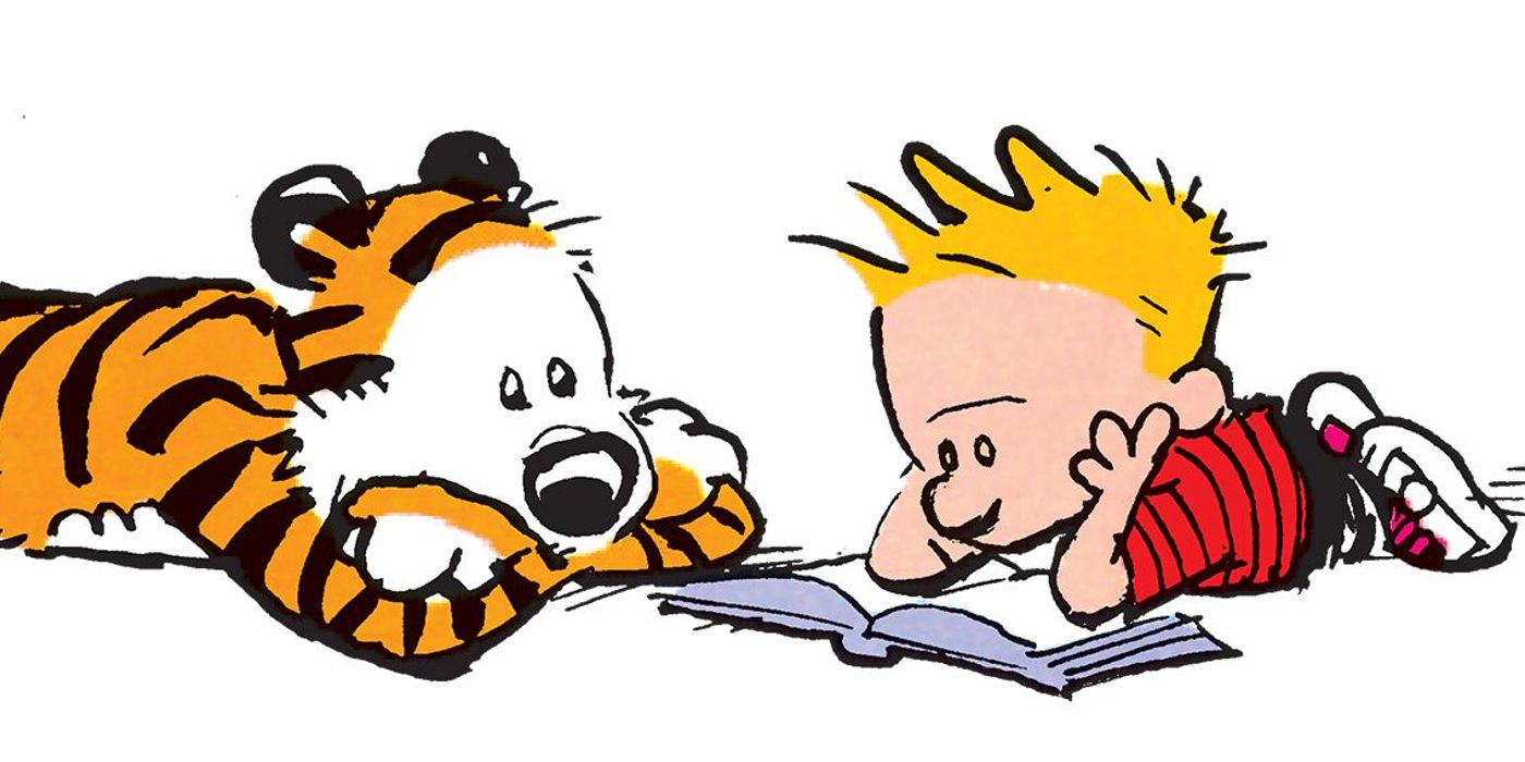calvin and hobbes lay on the ground together while reading through a book