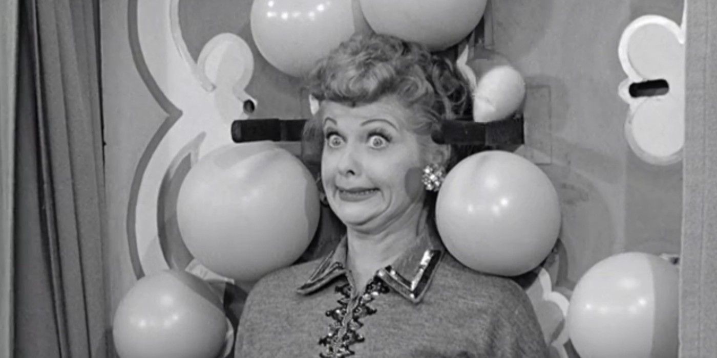 Lucy gives a terrified, wide-eyed smile while participating in a knife-throwing act in I Love Lucy, Lucy Tells The Truth.
