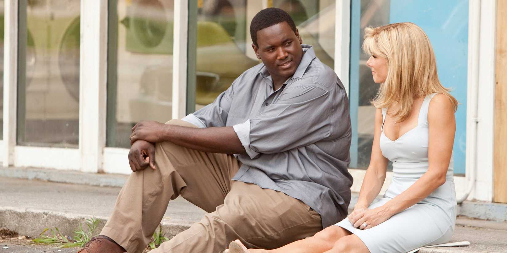 Michael Oher has a heart-to-heart with Leigh Anne Tuohy while sitting on a curb in The Blind Side