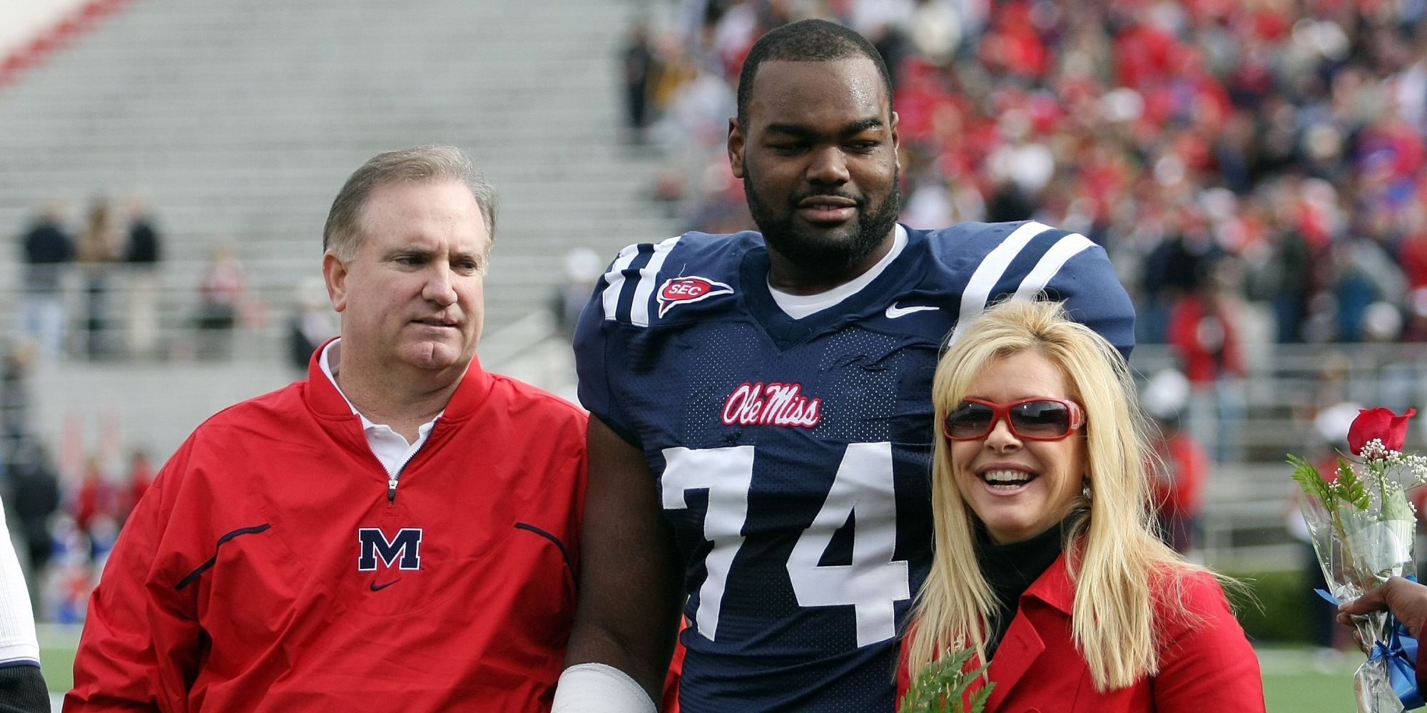 Sean Tuohy, Michael Oher, and Leigh Anne Tuohy pose for a picture after an Ole Miss football game