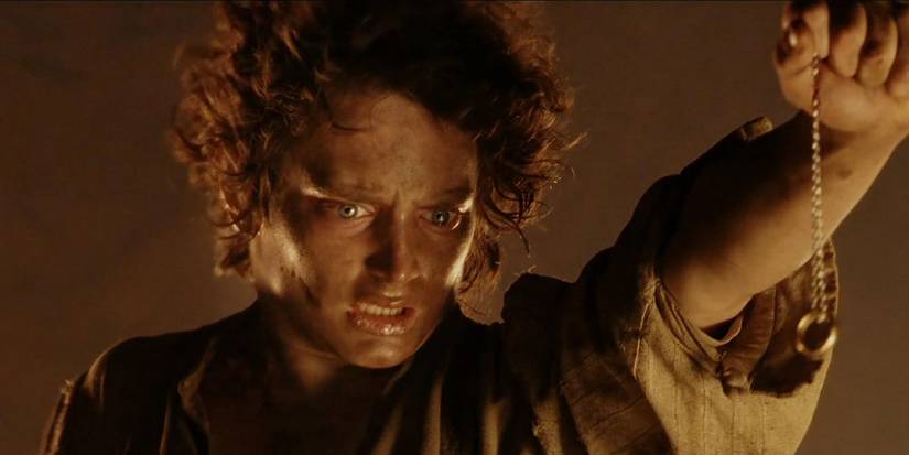 Frodo (Elijah Wood) holds the ring on a chain at Mount Doom in Lord of the Rings: The Return of the King.