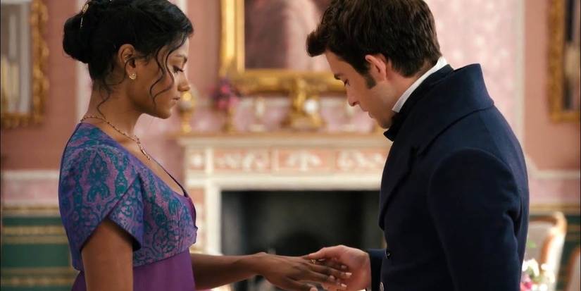 Anthony admires the ring on Kate's finger while holding her hand in Bridgerton