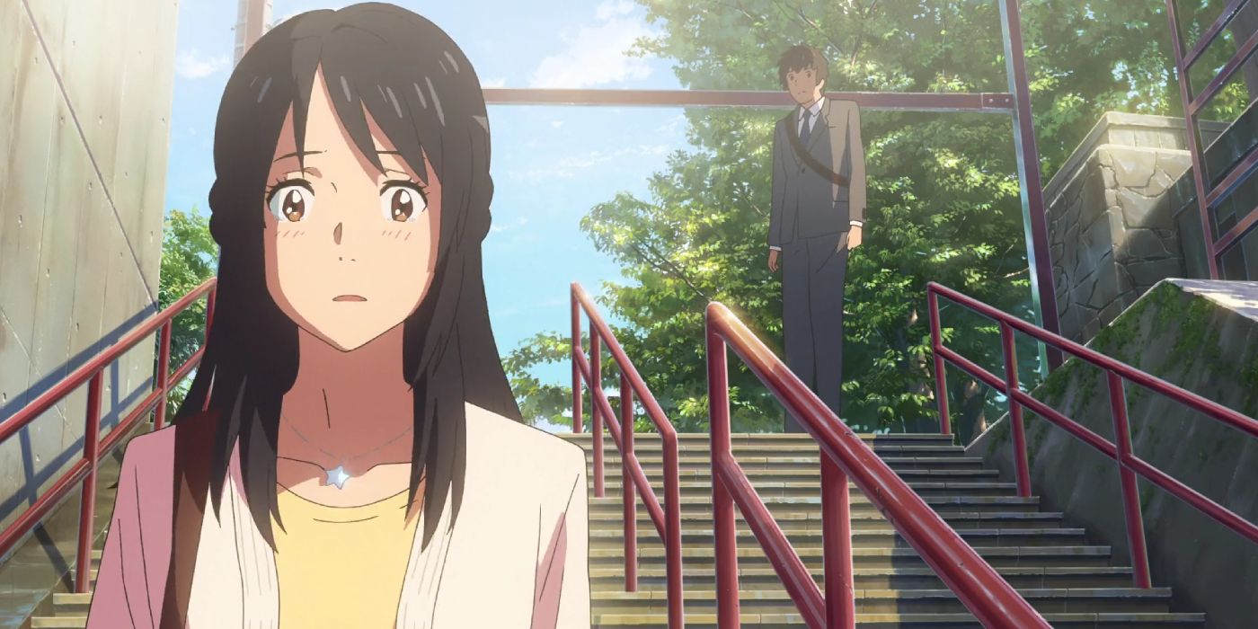 Mitsuha blushes in surprise as Taki stands at the stop of the stairs behind her in Your Name.