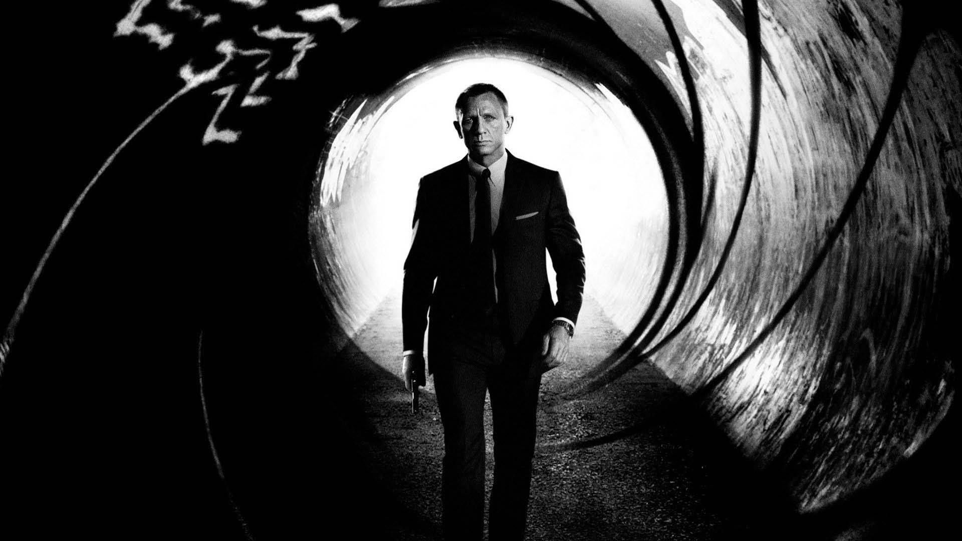 James Bond, played by Daniel Craig, walkign down a gun barrel in the opening sequence of 'No Time to Die'