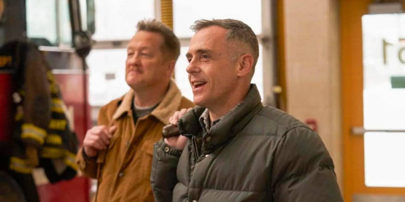 David Eigenberg as Christopher Herrmann stands in front of Christian Stolte as Randall 'Mouch' McHolland on Chicago Fire