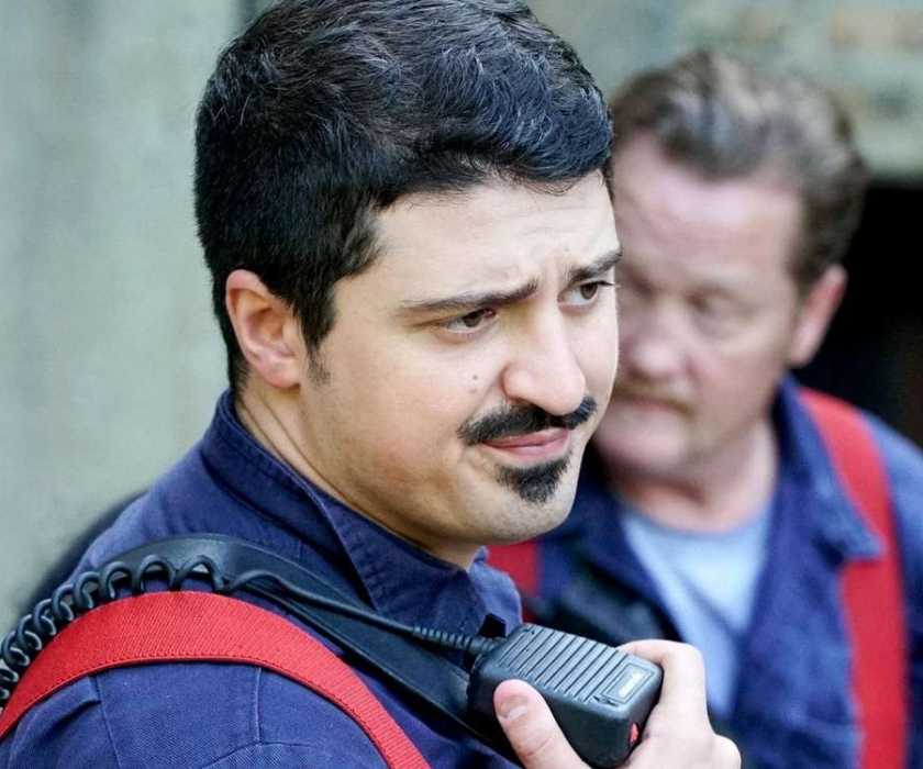 Yuri Sardarov as Brian 'Otis' Zvonecek stands in front of Christian Stolte as Randall 'Mouch' McHolland on Chicago Fire