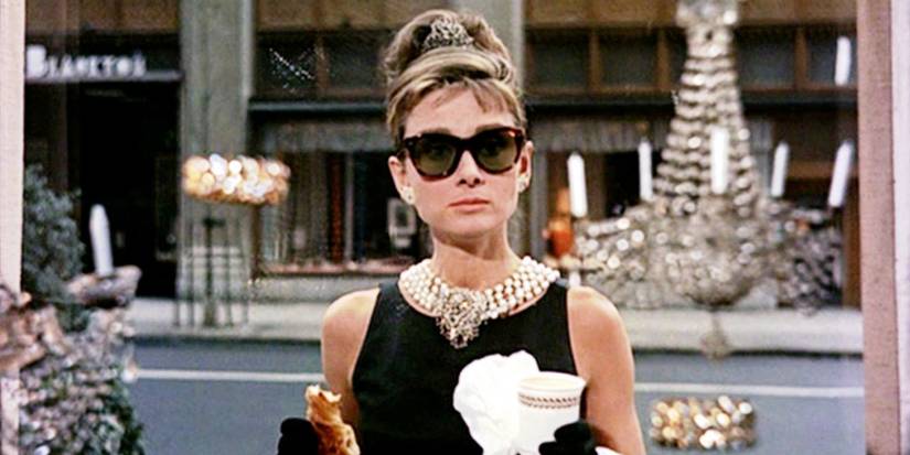 Audrey Hepburn as Holly Golightly wearing sunglasses and carrying a danish in Breakfast at Tiffany's