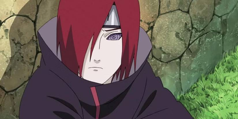 Young Nagato is frowning and has his Rinnegan activated as he sits with his back against the wall in Naruto: Shippuden.