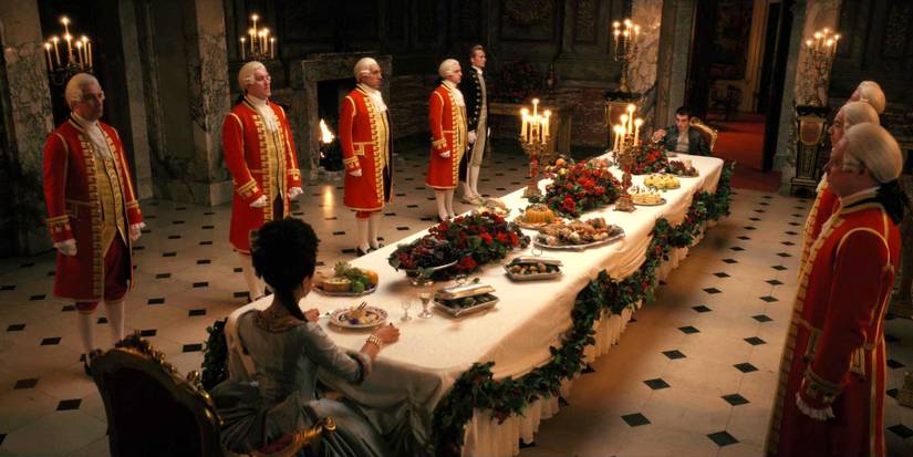 King George and Queen Charlotte sit at the dining table in Queen Charlotee A Bridgerton Story