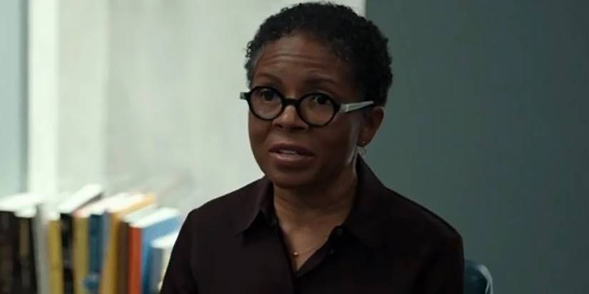LisaGay Hamilton wearing glasses sitting in an office in The Dropout.
