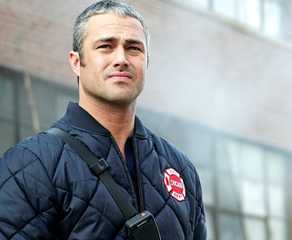 Taylor Kinney as Kelly Severide standing outside of a building in Chicago Fire episode "Deathtrap"