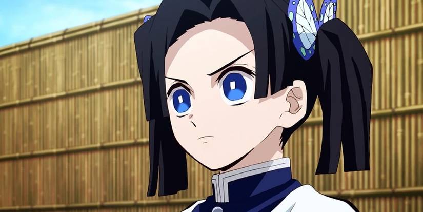 Aoi Kanzaki stares intensely against a wooden fence.