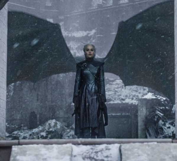 Daenerys Targaryen (Emilia Clarke) stands framed in front of damaged dragon wings in Game of Thrones